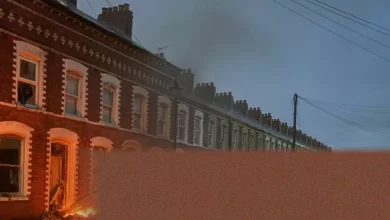 Burnt-out cars and debris on a residential street in Belfast after a night of rioting.