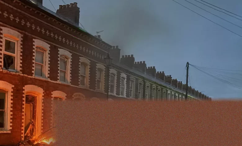 Burnt-out cars and debris on a residential street in Belfast after a night of rioting.