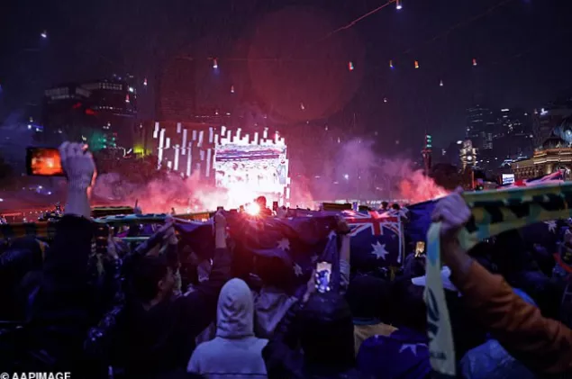 Flares burning on the ground among spectators during the Socceroos match at Federation Square