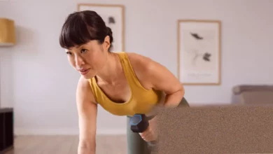 Woman in her forties performing a squat with dumbbells at home