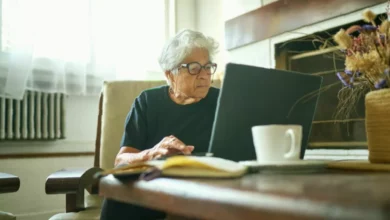 Older couple reviewing pension paperwork at a kitchen table in a British home.