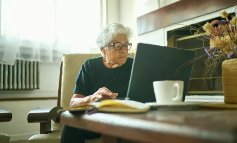 Older couple reviewing pension paperwork at a kitchen table in a British home.