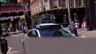 A self-driving Jaguar SUV navigating a narrow London street during summer trials
