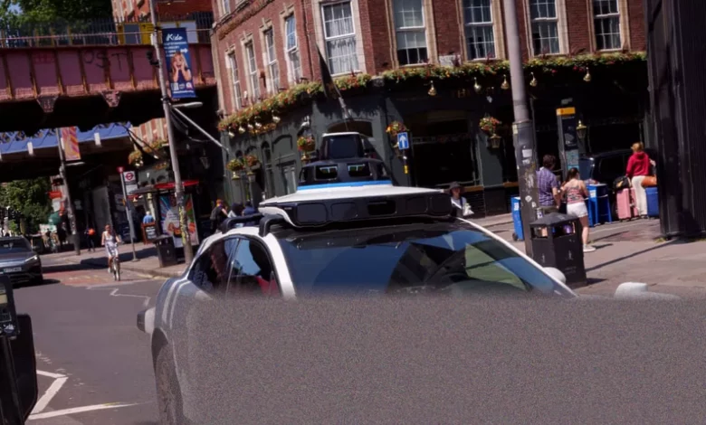 A self-driving Jaguar SUV navigating a narrow London street during summer trials