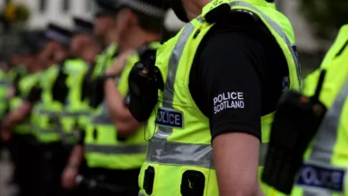 Police officers confront a crowd of demonstrators on Glasgow's Buchanan Street