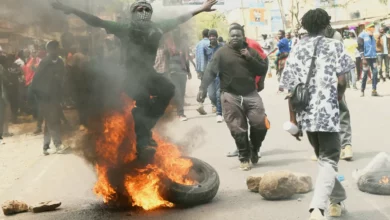 Crowd of protesters gathering on a dusty street in Nanyuki town, Kenya