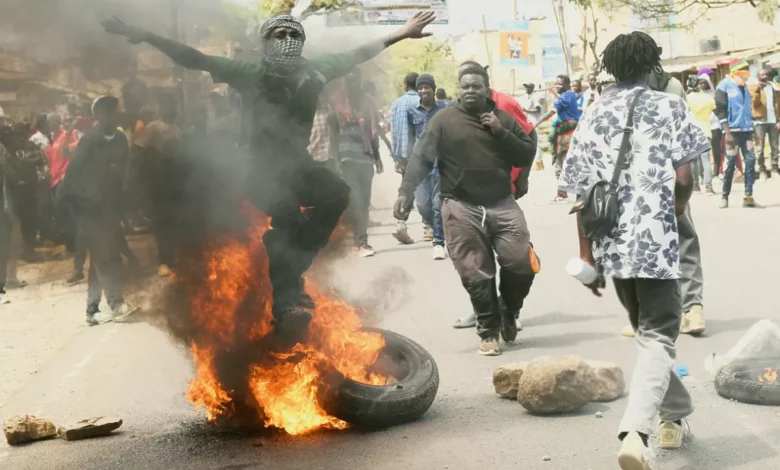 Crowd of protesters gathering on a dusty street in Nanyuki town, Kenya