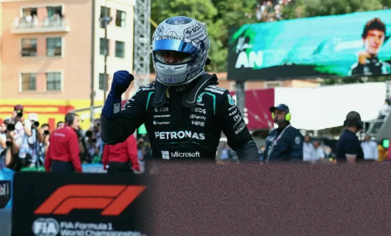 A Formula 1 car speeds around a tight corner on the sunlit Monaco street circuit during qualifying.