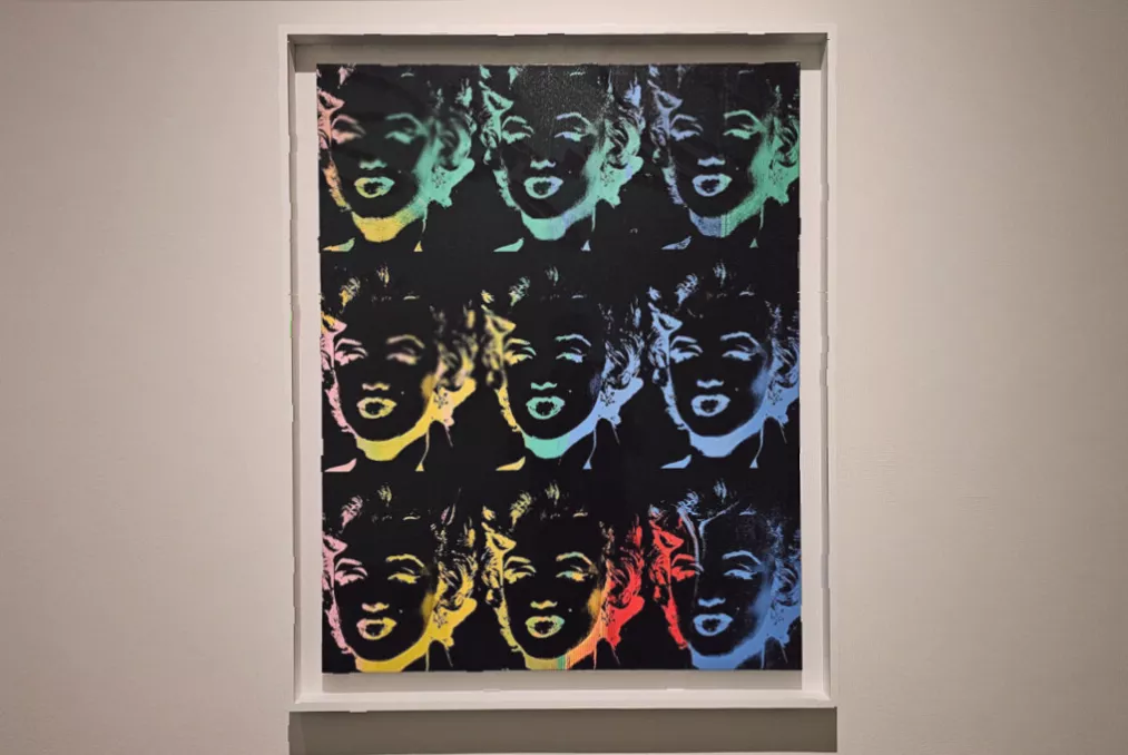 A wall display contrasting a Warhol silkscreen print with a small early childhood photo of Monroe