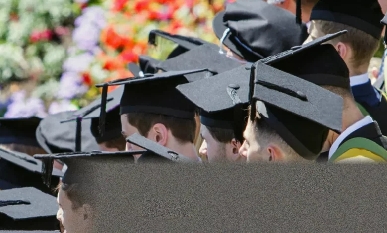 Students walking across a university campus with backpacks between red-brick buildings
