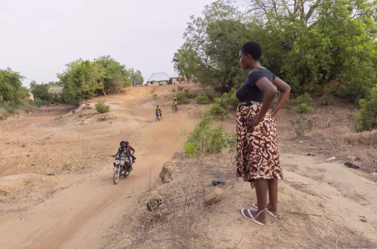 A mother carrying twins outside a basic health clinic in Bongo District