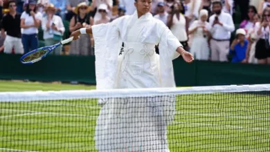 Tennis player walks onto Court 3 in layered white kimono with embroidered cranes and cherry blossoms