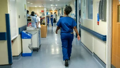 A hospital maternity ward with medical staff attending to a patient in a bed