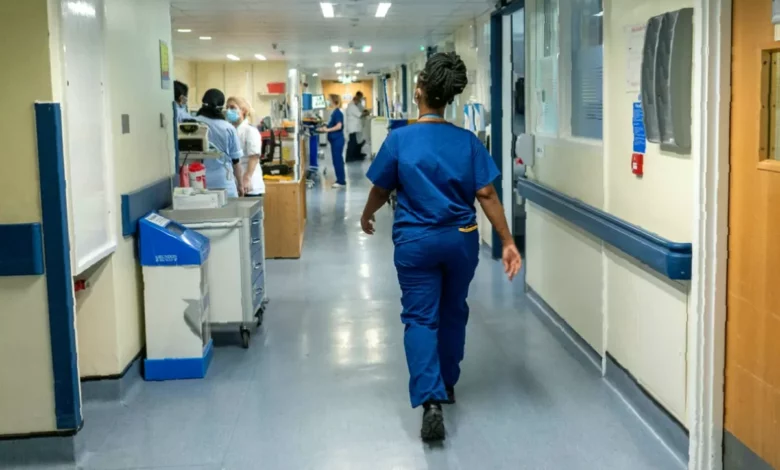 A hospital maternity ward with medical staff attending to a patient in a bed