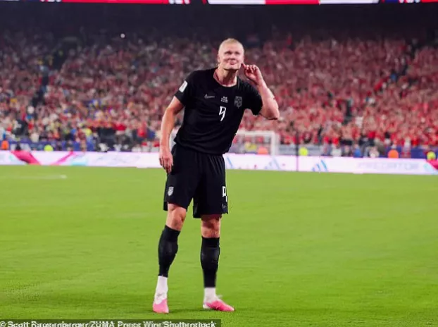 A drum being beaten on the field as footballers sit in a coordinated rowing motion with fans