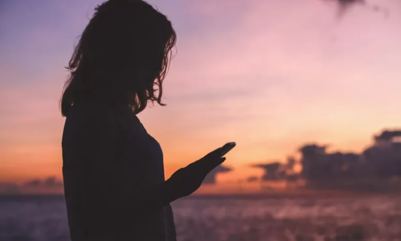 A teenager looking at a smartphone screen displaying a chatbot conversation