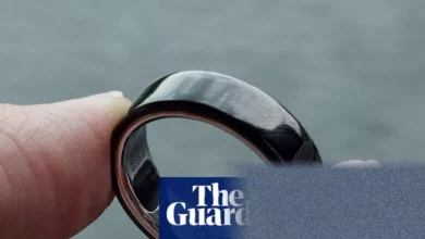 Sleek black titanium smart ring resting on a table surface