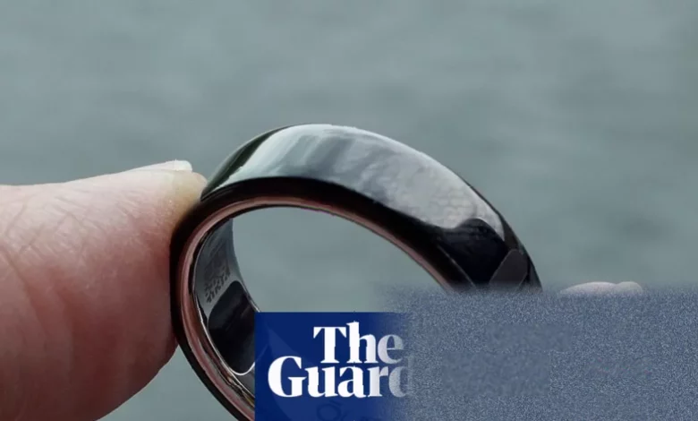 Sleek black titanium smart ring resting on a table surface