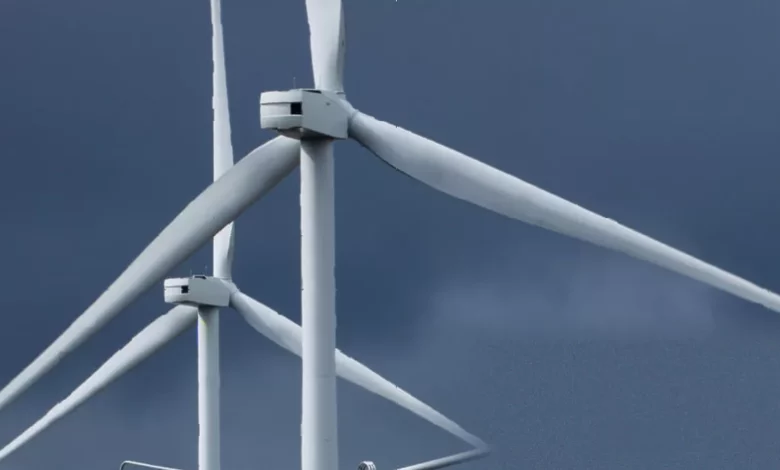 Wind turbines and solar panels in a field, representing renewable energy projects awaiting grid connection