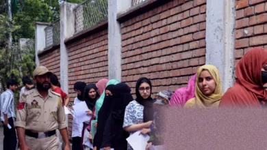 Students queue outside an Indian exam centre with airport-style security checks.