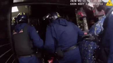 Police officers examining a safe filled with bundles of cash at a money exchange shop in East Ham