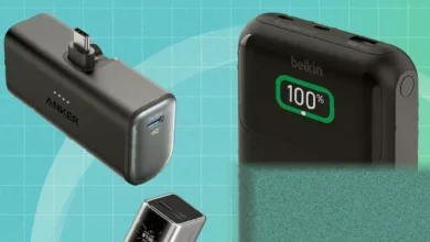 A collection of various power banks and battery packs arranged on a wooden table for testing.