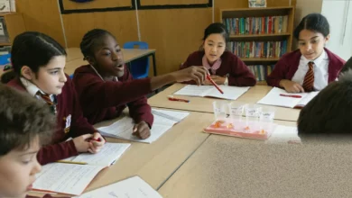 Children and teachers in a London classroom using chalkboards and paper instead of screens