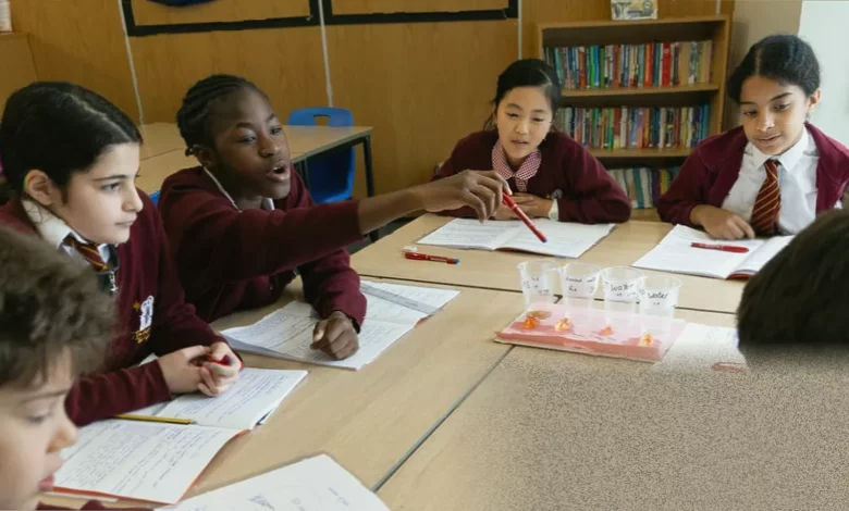Children and teachers in a London classroom using chalkboards and paper instead of screens