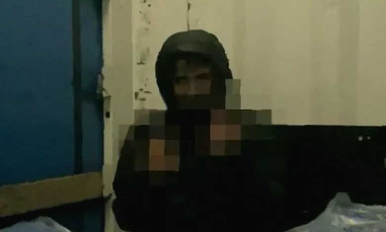 Three men hiding among packages in a lorry trailer, filmed on a mobile phone at night.