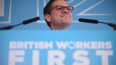 Robert Jenrick speaking at a podium during a campaign event in Makerfield