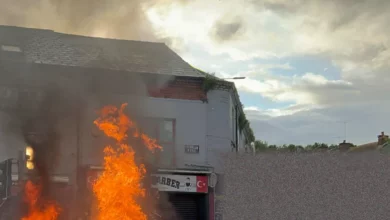 Masked crowds block a road and set vehicles alight during a far-right protest in Belfast