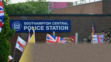 Crowd of protesters in Southampton streets holding drinks and chanting near a police cordon