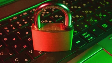 A person typing on a laptop in a dimly lit office, with a padlock icon glowing on the screen.