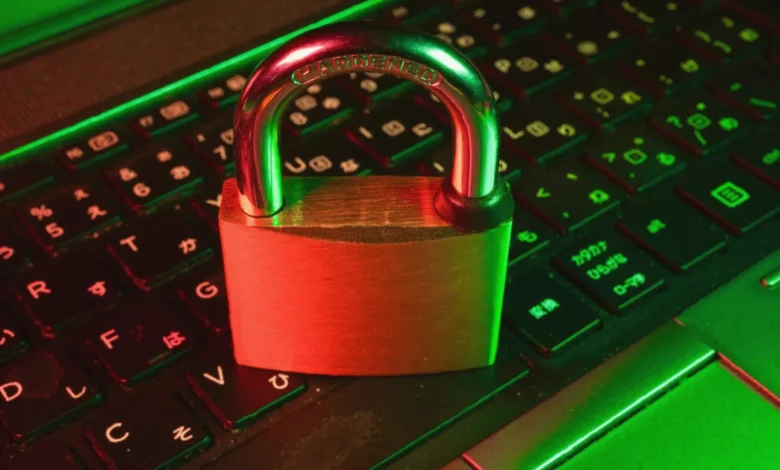A person typing on a laptop in a dimly lit office, with a padlock icon glowing on the screen.