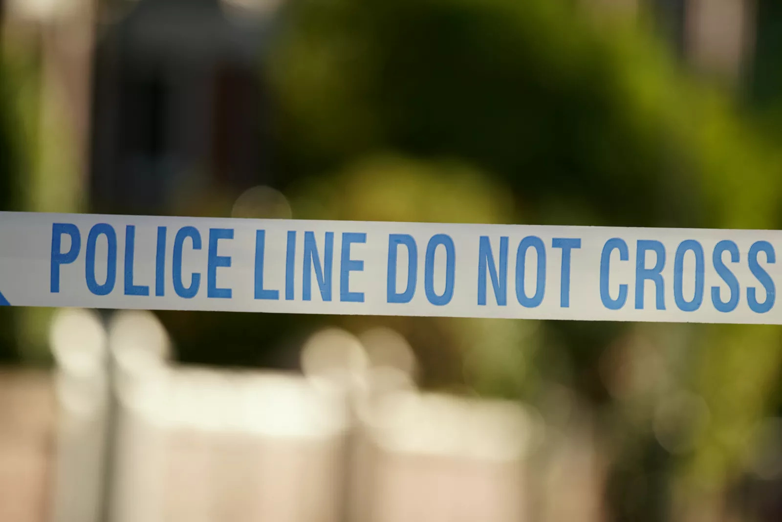 A police van parked near shops on a London street following a murder investigation