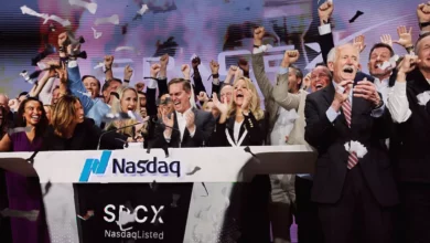 Crowd of traders watching stock market screens showing SpaceX IPO data