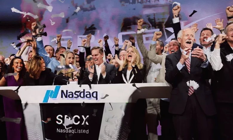 Crowd of traders watching stock market screens showing SpaceX IPO data