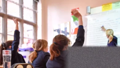 Classroom in an English state school with empty desks and a whiteboard