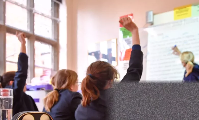 Classroom in an English state school with empty desks and a whiteboard