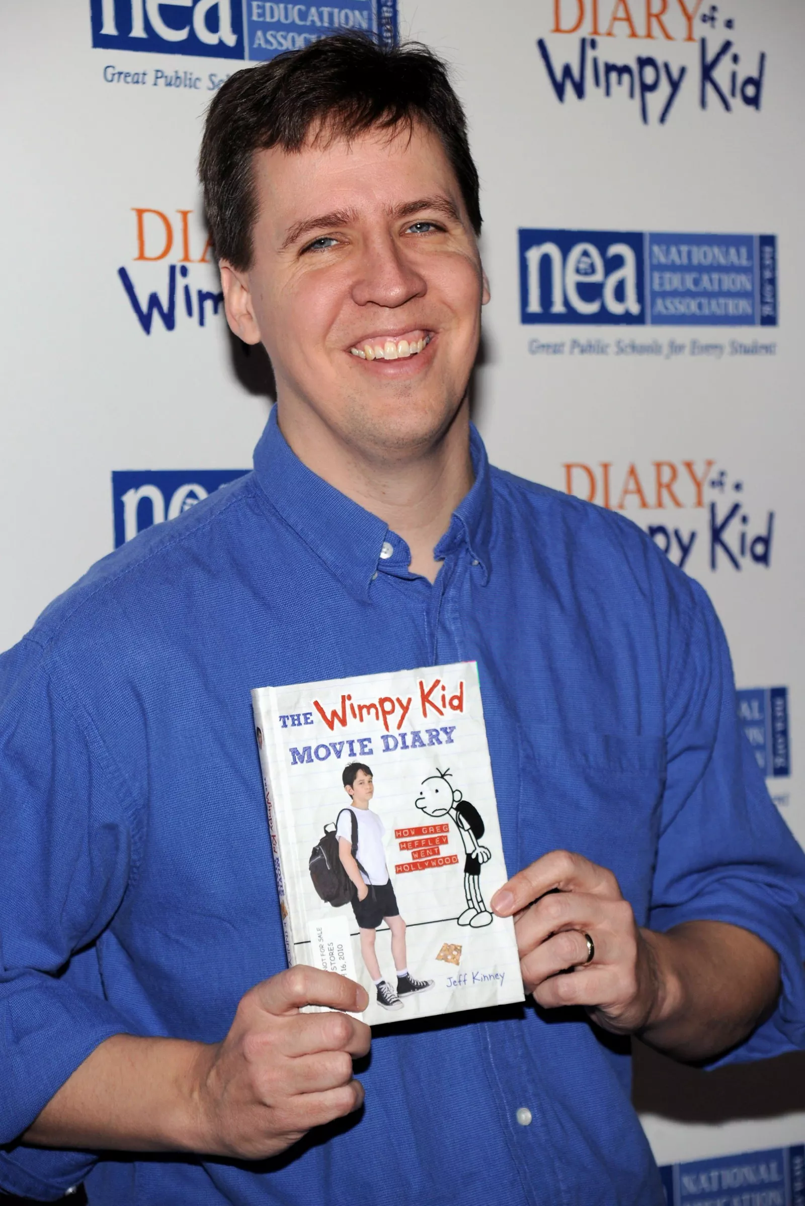 A close-up of a Diary of a Wimpy Kid book lying open on a school desk
