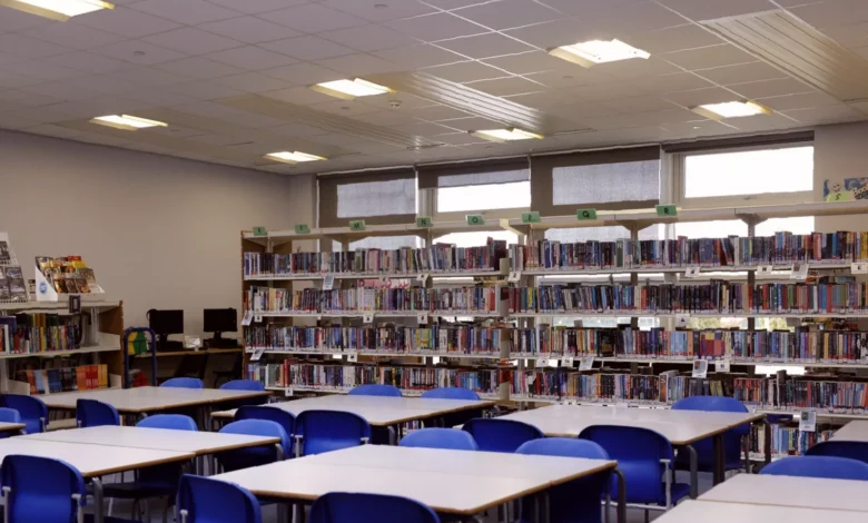 A secondary school library with shelves of children's books, some labelled for primary ages
