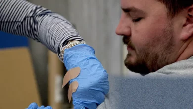 Retracted vaccine study documents on a desk with a laptop nearby