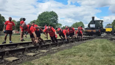 Railway workers straining to pull a 25-tonne steam locomotive along tracks at Didcot Railway Centre