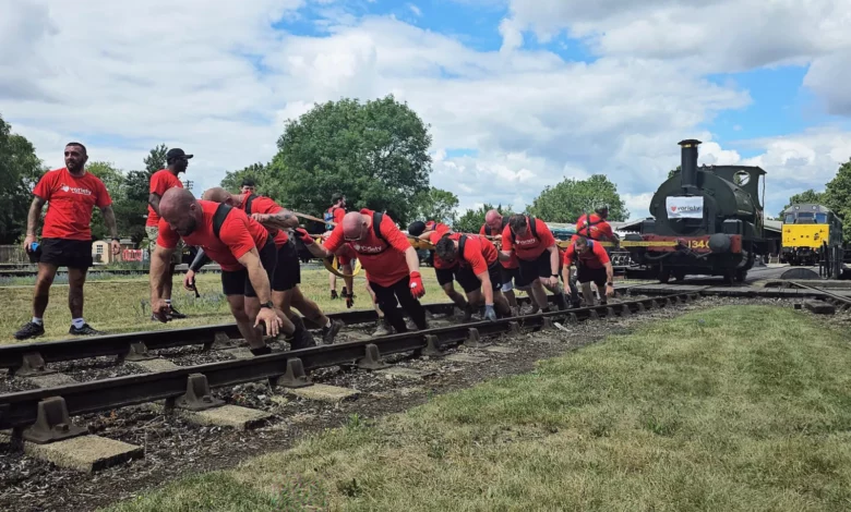 Railway workers straining to pull a 25-tonne steam locomotive along tracks at Didcot Railway Centre