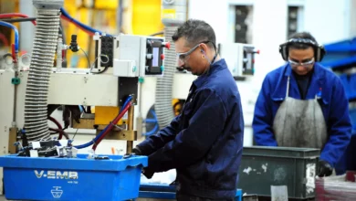 Factory production line with workers assembling components under bright industrial lighting