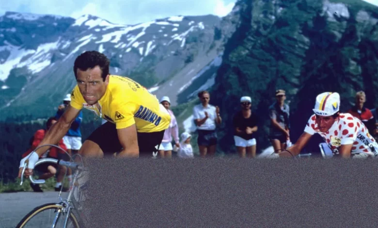 A young cyclist in racing kit climbs a steep mountain road during a stage race