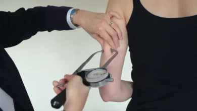 A worker undergoing a health assessment at a desk in a modern UK office.