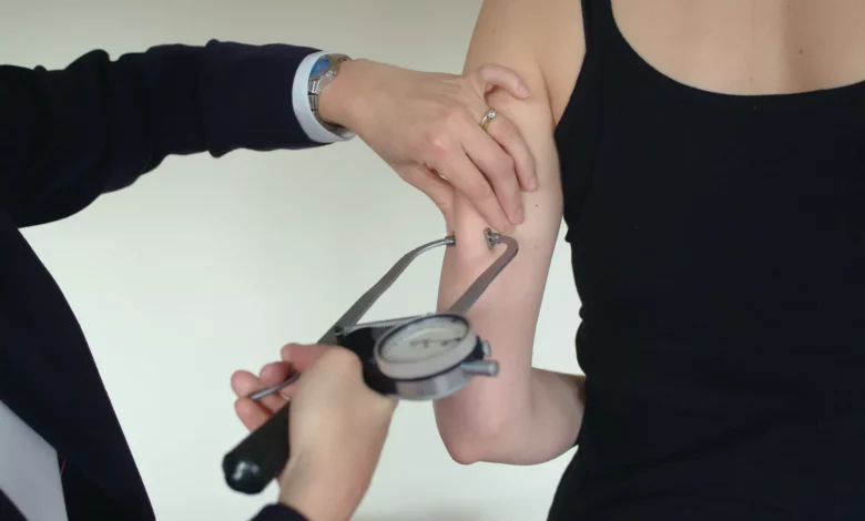 A worker undergoing a health assessment at a desk in a modern UK office.