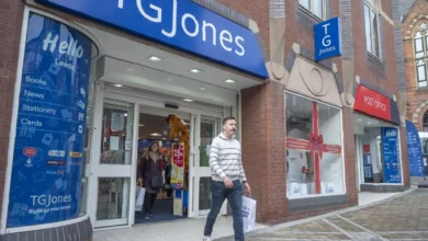 A closed TG Jones storefront with a sign reading "closed" in a British high street shopping area.